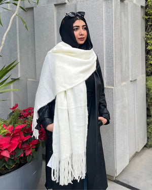 Close-up of soft mohair texture and fringe detailing on off-white shawl