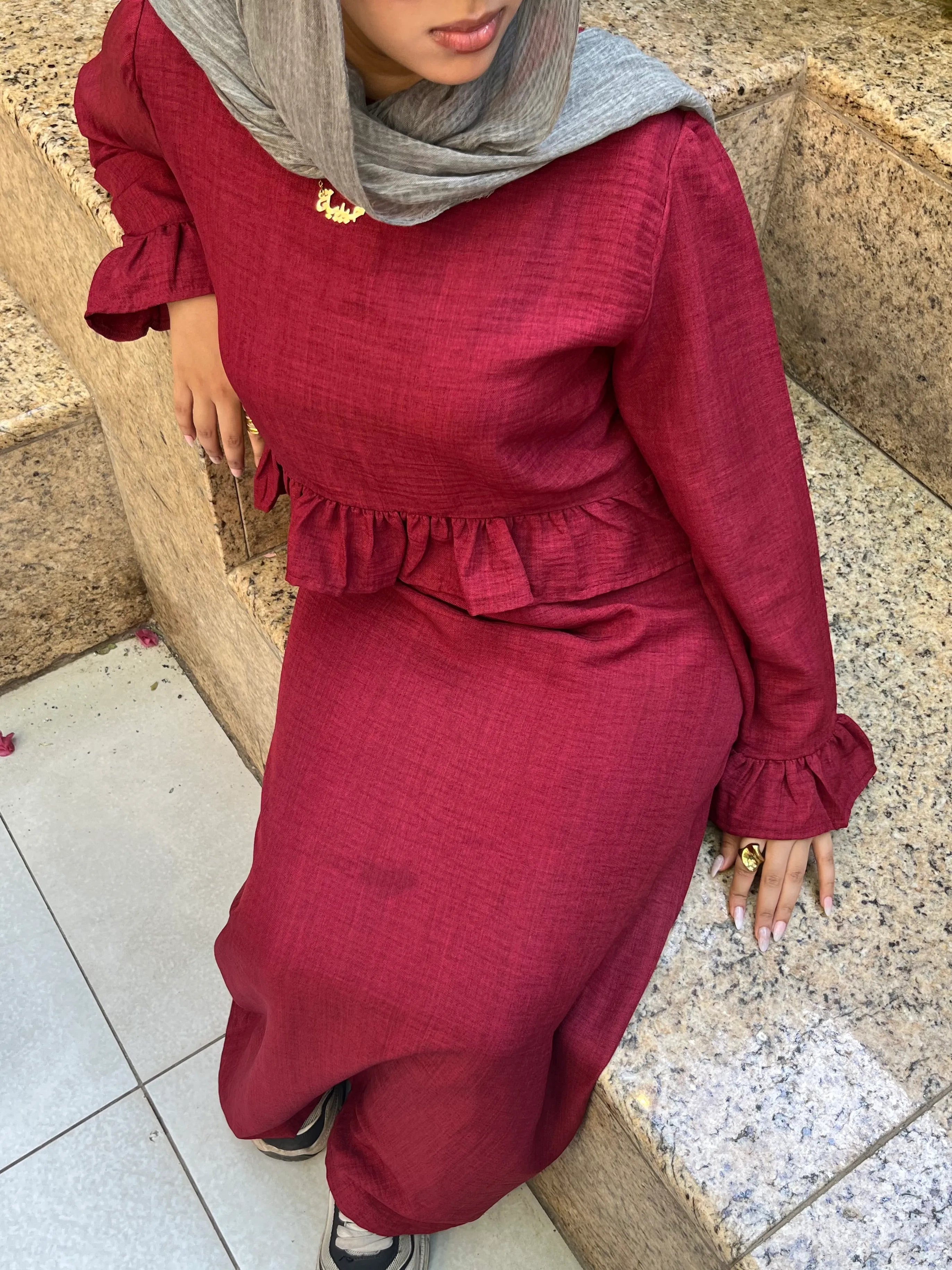 Elara Dress burgundy two-piece set seated view showing ruffle detail